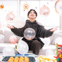 たこ焼き器を前に両手を広げて喜ぶホームパーティーの男性の写真