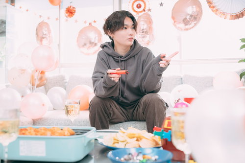 推しとゲームを楽しむ男性がホームパーティーでシャンパンを楽しむ