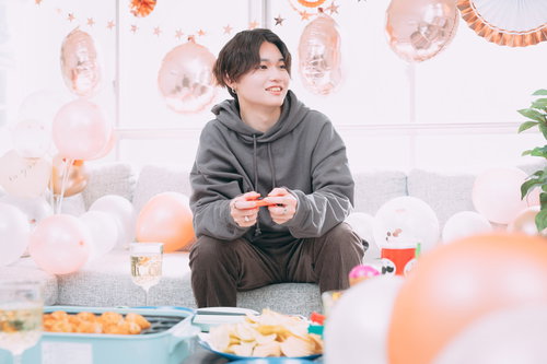 パーティーでゲームコントローラーを握る男友達