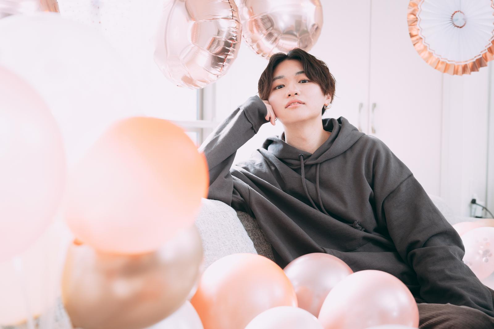 グレーのパーカーを着た男性がホームパーティーで誕生日を祝う［モデル：SHUN］