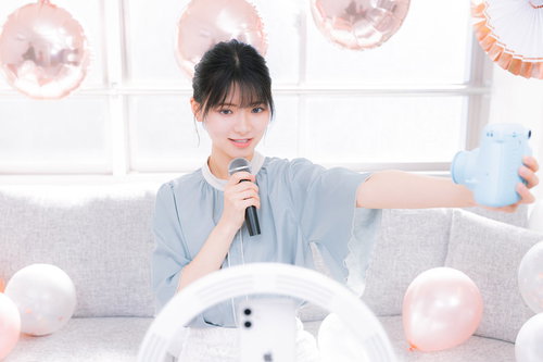 お祝いの生配信中、マイクを握る女子ライバーの配信風景