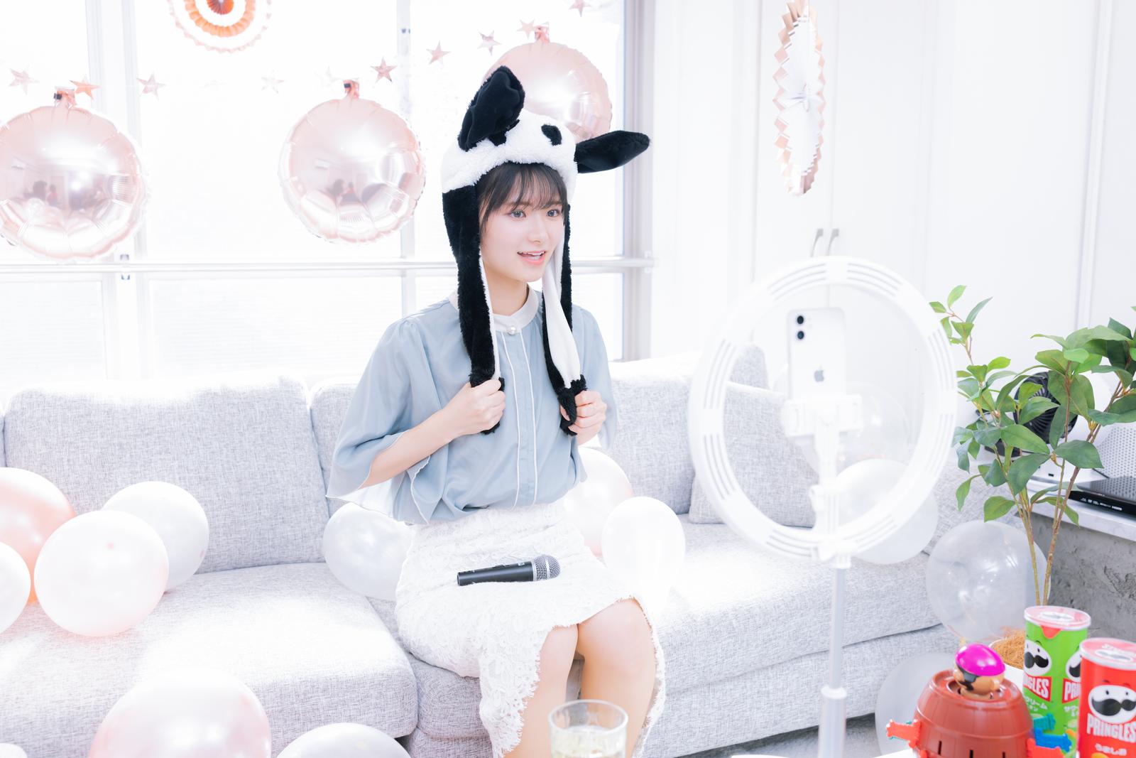 ホームパーティーの装飾の中でマイクを持つ女性YouTuber［モデル：モデルリリース］