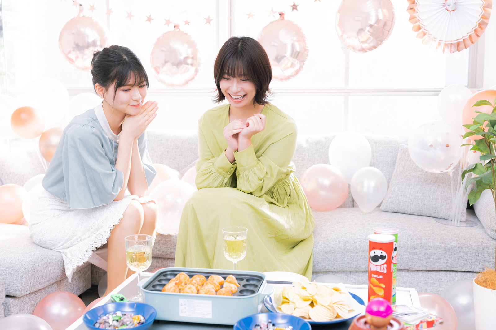 たこ焼きプレートとシャンパンを囲んで楽しむ女性2人の女子会風景［モデル：夏実 モデルリリース］