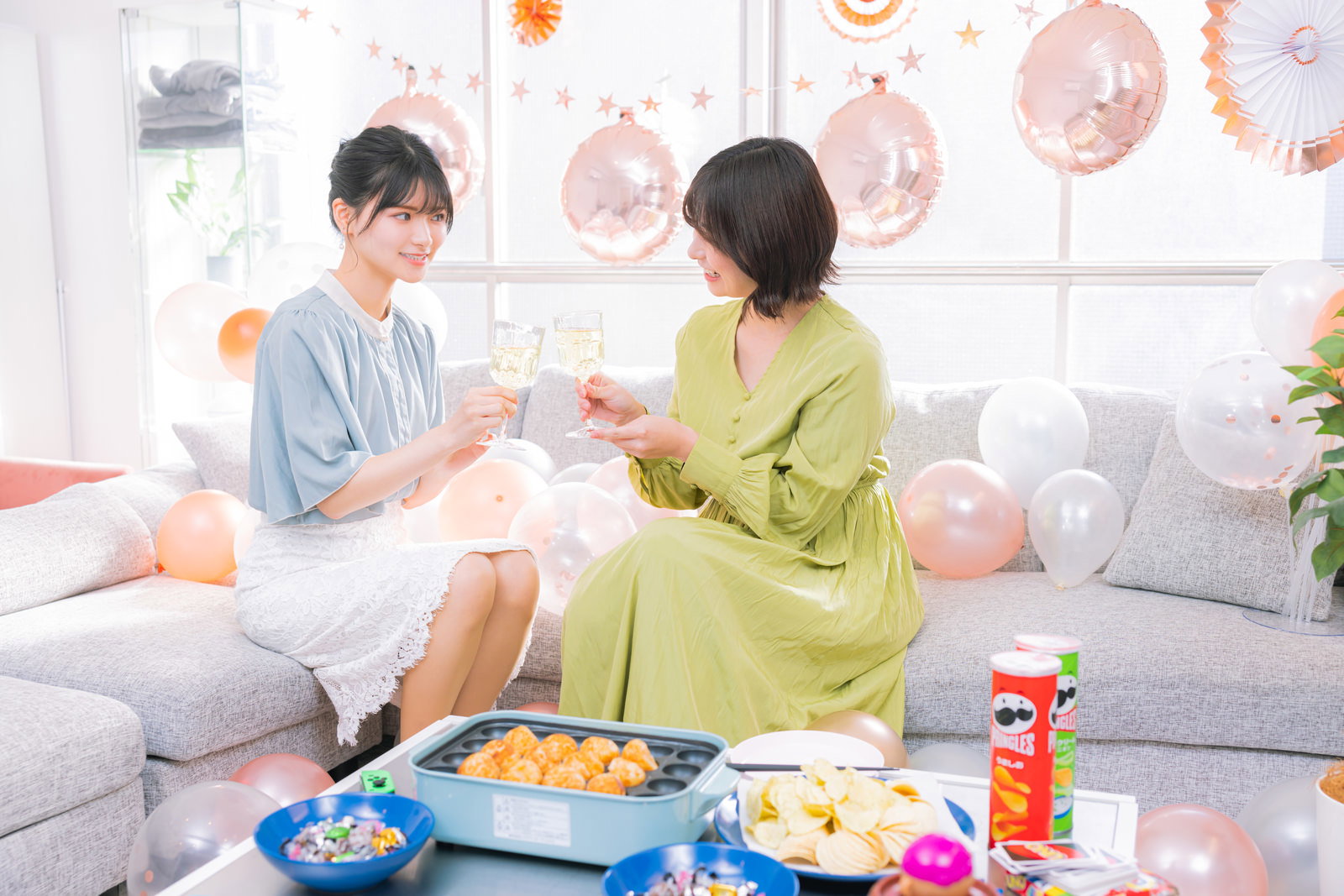 ホームパーティーでシャンパングラスで乾杯する女性2人［モデル：モデルリリース 夏実］