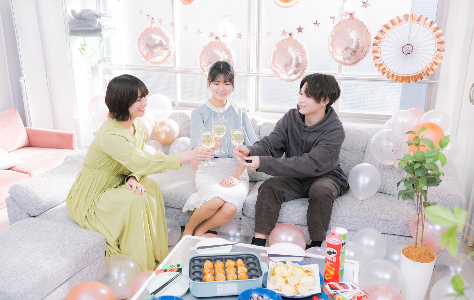 リビングルームでシャンパンを持って乾杯する男性と女性［モデル：モデルリリース 夏実 SHUN］