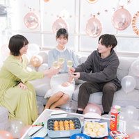 ホームパーティーでシャンパンを持って乾杯する男女の写真