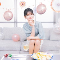 ホームパーティーの準備を整えてソファに座る女性の写真