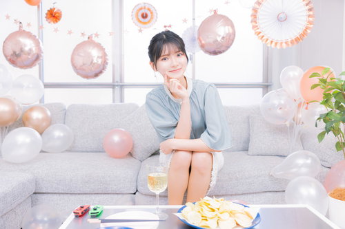 ホームパーティーの準備を整えてソファに座る女性