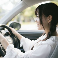 公道デビューを控えた女性ドライバーがハンドルを握るの写真