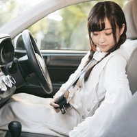 シートベルトを装着して安全運転する女性ドライバーの写真