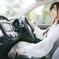 前方に注意してシフトレバーをドライブに入れる女性の写真