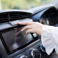 ハザードランプ（非常点滅表示灯）を押す運転席の手の写真