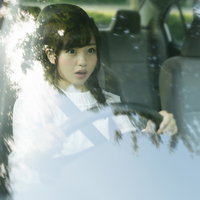 死角から飛び出してきた人を避けるため急ブレーキする若い女性ドライバーの写真