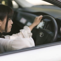 車の中で待ち合わせ相手を待つ女性運転手のドライブ風景の写真