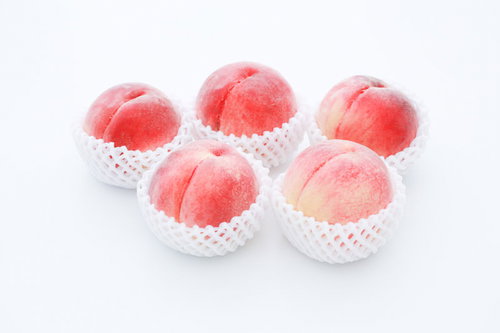 品質のいい桃（ピーチ）を白い容器に詰めたもの