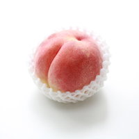 白いネットに包まれた高級な桃、丁寧に梱包された贈答品用フルーツの写真