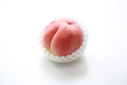 白いネットに包まれた高級な桃、丁寧に梱包された贈答品用フルーツ