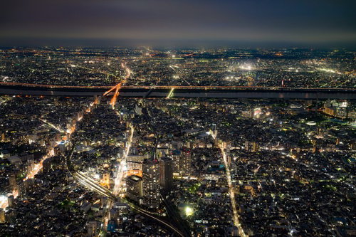 河を挟んで広がる街並みの夜景、複数の橋と街灯が照らす都市風景