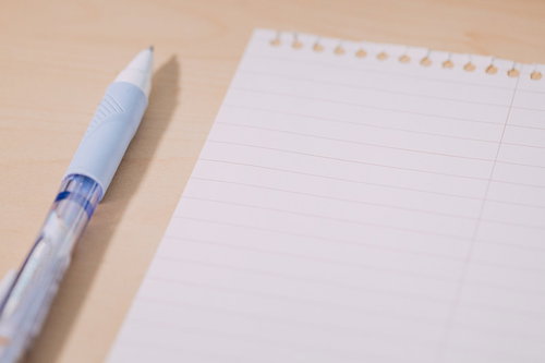 木製デスクに置かれた白い便箋とペン、手紙作成シーン