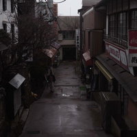 雨降った後の門前町の商店街の濡れた石畳と建物の写真