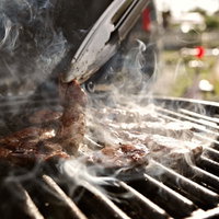 炭火で焼くBBQのお肉とグリル調理の風景の写真