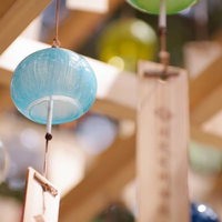 軒下に吊るされた青い風鈴が涼しげに揺れる夏の風物詩の写真