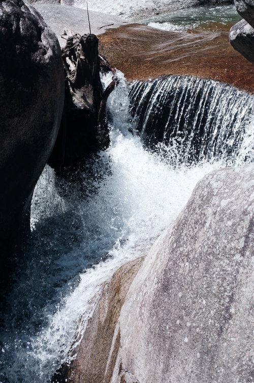 岩間を流れ落ちる滝の白いしぶきと渓流
