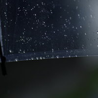 透明なビニール傘に残る雨粒と水滴のしずくの写真