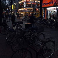 日が暮れた伊勢佐木商店街の夜景、街灯に照らされた駐輪場と開店した店舗の明かりの写真