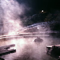 深夜の賽の河原温泉公園で足湯に浸かるカップルの写真