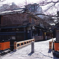雪が積もった京都祇園の巽橋と周囲の町並みの写真