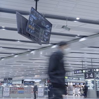 新大阪駅の駅構内を歩く人々と案内表示板の写真