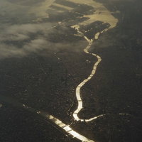 上空から太陽に反射した荒川と隅田川の河川風景の写真