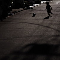 路上でボールを使って遊ぶ子供たちへの交通注意喚起の写真