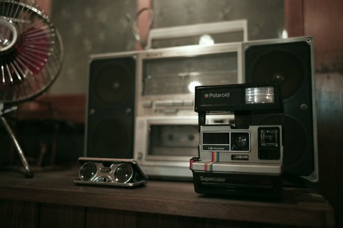昭和レトロな緑色のラジカセと白いポラロイドカメラ