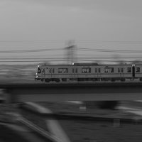 多摩川の陸橋上を走る東急電鉄の電車の流し撮りの写真