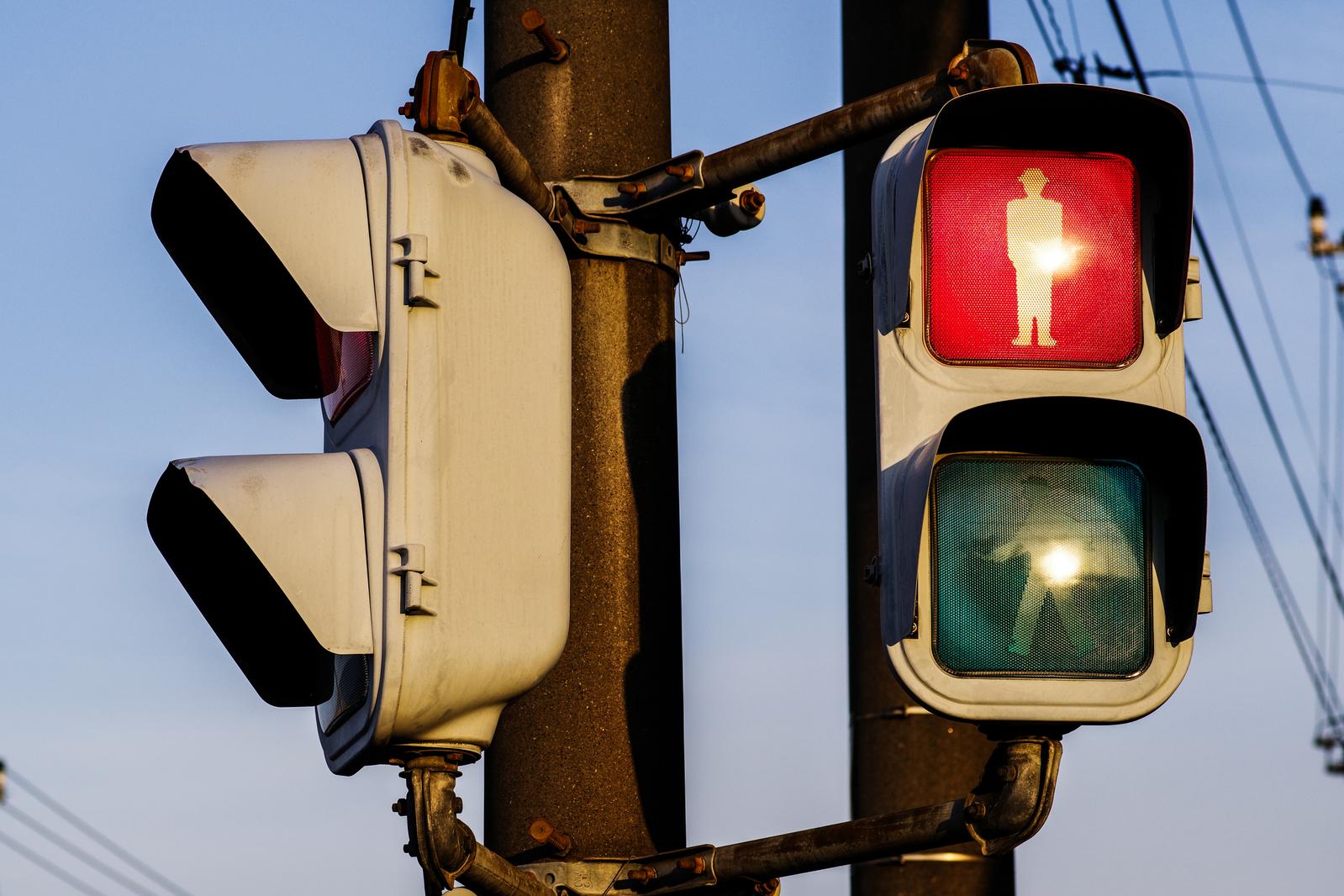 斜陽を背景に赤く点灯した歩行者用信号機