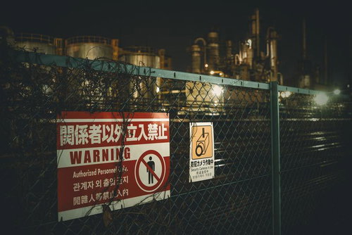 立入禁止のフェンス越しに望む夜間の工場夜景