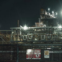 配管や構造物が複雑に絡み合う工場夜景の写真