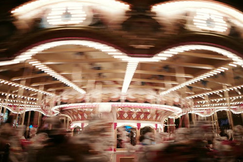 夜間にライトアップされて回転するメリーゴーランド