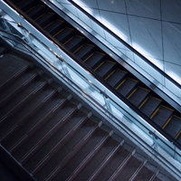 上下に並行するエスカレーターと階段の交差点の写真