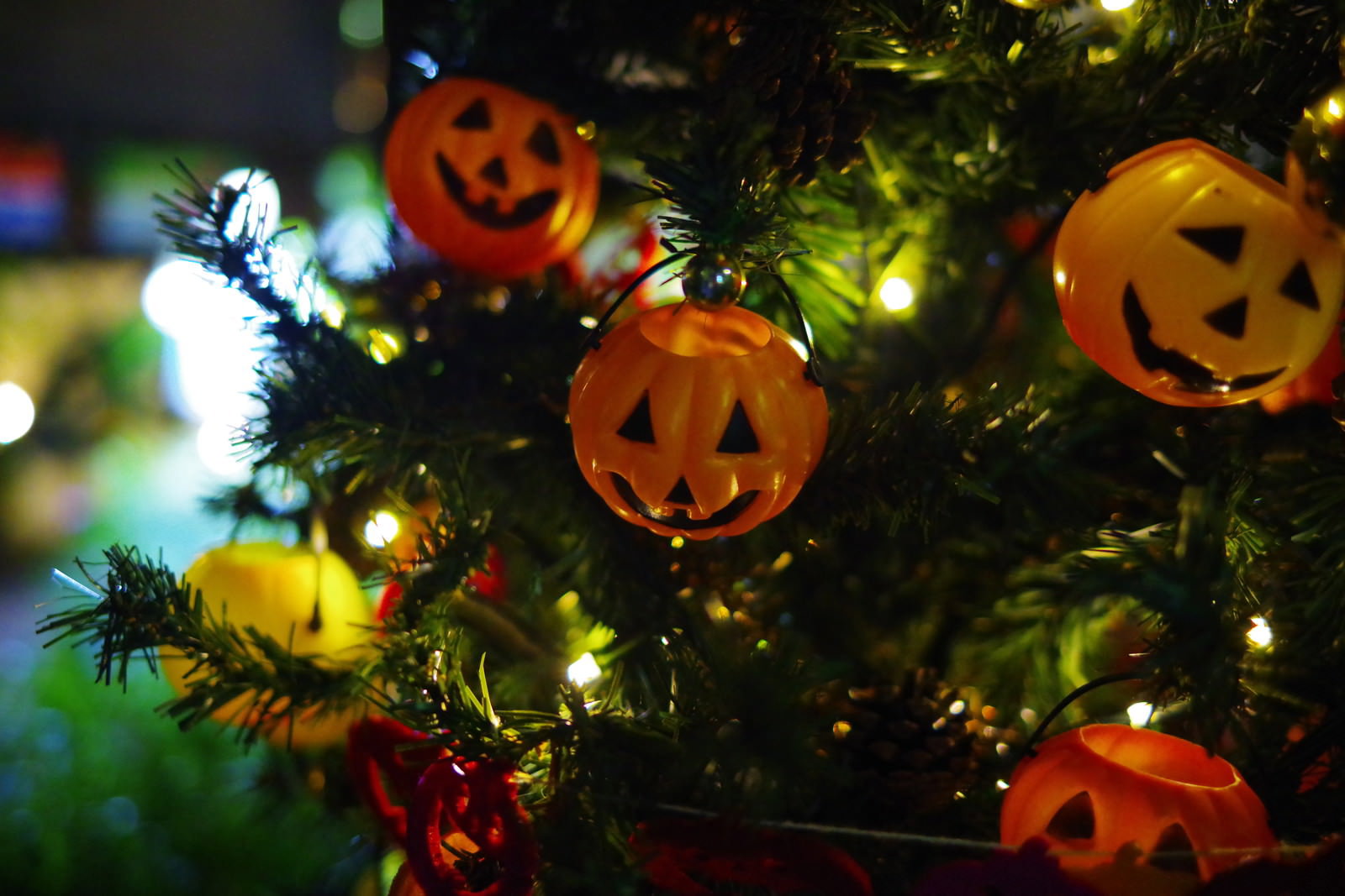 ツリーに飾られたオレンジ色のハロウィンかぼちゃオーナメントとイルミネーション