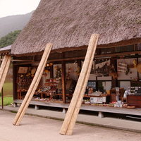 世界遺産・菅沼集落の軒先に並ぶ土産物と合掌造り民家の写真