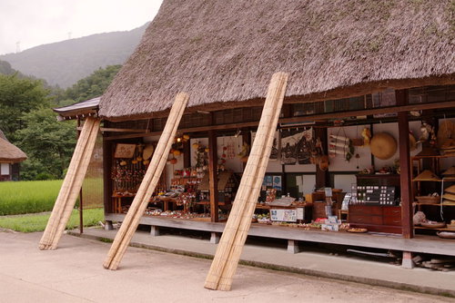 世界遺産・菅沼集落の軒先に並ぶ土産物と合掌造り民家