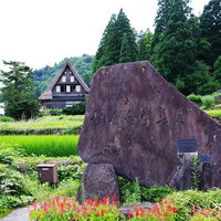 相倉集落の緑の田畑に囲まれる石碑（富山県南砺市）の写真