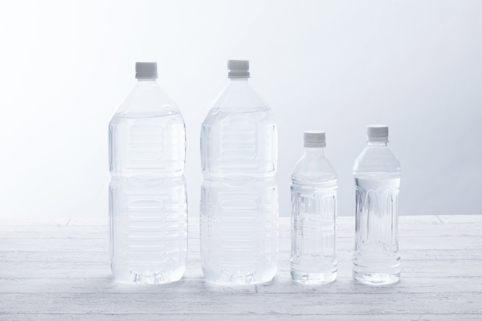 白い背景に並んだ2Lペットボトル2本と500mLペットボトル2本