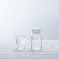 透明なグラスとピッチャーに入ったミネラルウォーターの写真