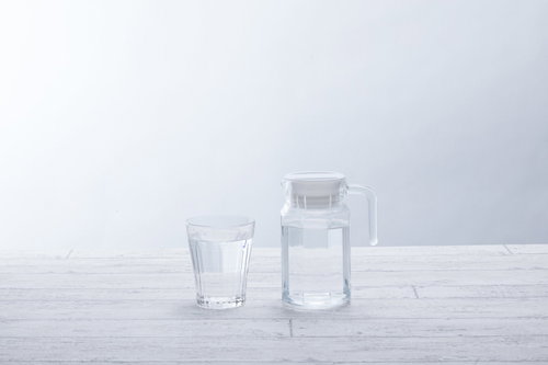 透明なグラスとピッチャーに入ったミネラルウォーター