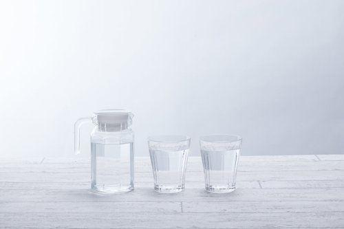 ミネラルウォーターの入ったグラスとガラスポット