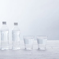水が入ったペットボトル2本とグラスの写真